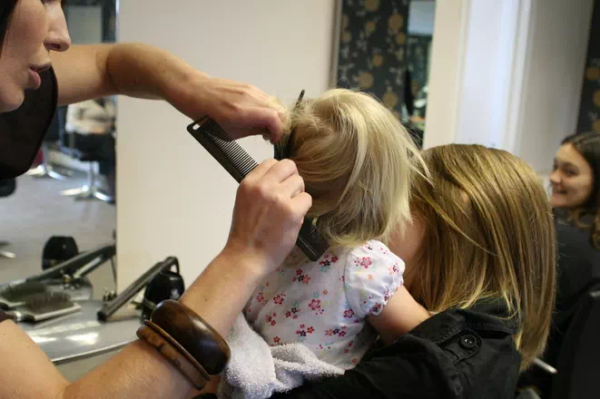 Coiffeuse en train de couper les cheveux